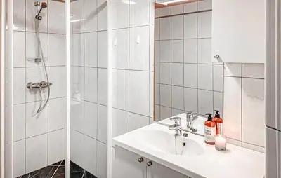 a white bathroom with a sink and a shower at 4 Bedroom Awesome Home In Luster in Luster