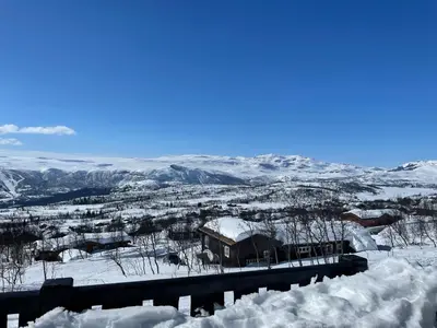 a snow covered town with a train station and mountains at Charming Family Cabin With Stunning Mountain Views in Beitostøl