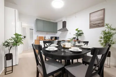 a dining room with a black table and chairs at Bergen City Center Bryggen in Bergen