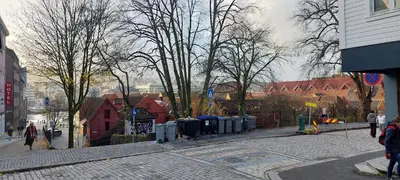 a city street with trees and trash cans on a street at Bergen City Center Bryggen in Bergen