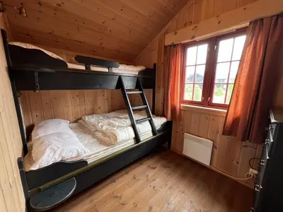 a bedroom with bunk beds in a wooden cabin at Modern Retreat By Beitostølen Ski Stadium in Beitostøl