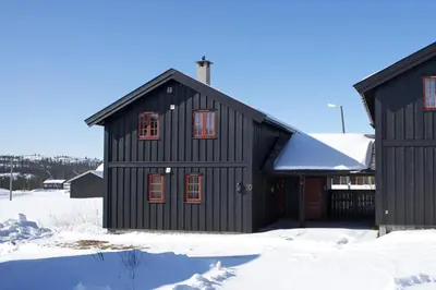 a black building with snow on the ground at Modern Retreat By Beitostølen Ski Stadium in Beitostøl