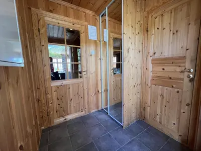 a room with wooden walls and a glass door at 3-Story Apartment Near Slopes With Sauna And Views in Beitostøl
