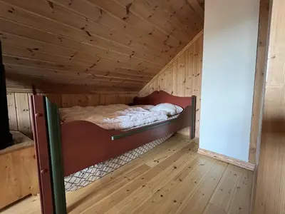 a bedroom with a bed in a wooden room at 3-Story Apartment Near Slopes With Sauna And Views in Beitostøl