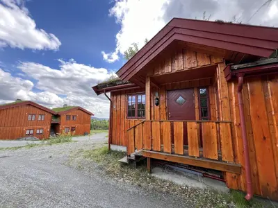 a wooden cabin with a red roof at 3-Story Apartment Near Slopes With Sauna And Views in Beitostøl