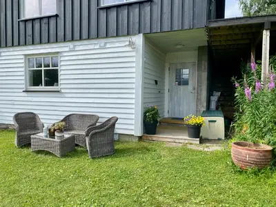 a house with two wicker chairs and a porch at Leilighet i enebolig in Fagernes