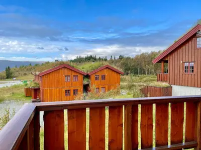a group of wooden buildings with a wooden deck at 3-Story Apartment Perfect For Up To 10 Guests in Beitostøl
