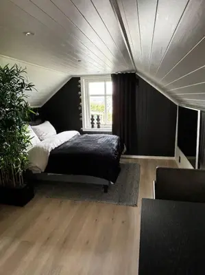 a bedroom with a bed and a large window at NY og moderne studioleilighet med elbil lading in Gjøvik