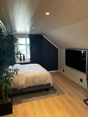a bedroom with a bed and a flat screen tv at NY og moderne studioleilighet med elbil lading in Gjøvik