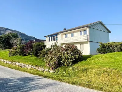 a white house on a hill with a street at 12 person holiday home in Davik in Davik