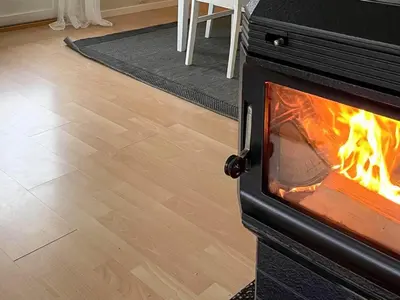 a stove with a fire in a living room at 12 person holiday home in Davik in Davik