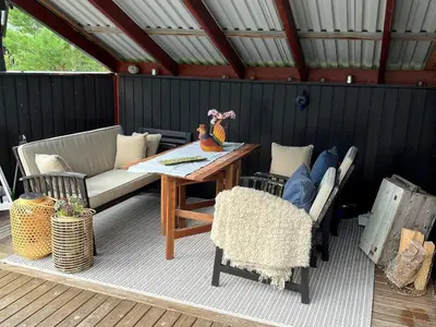 a patio with a table and chairs on a deck at 8 person holiday home in frosta in Vollen