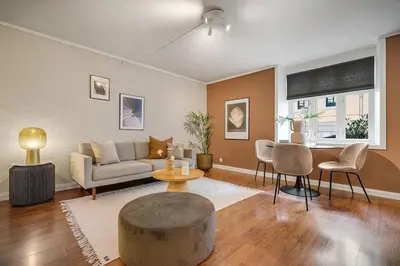 a living room with a couch and a table and chairs at Leilighet - midt i sentrum! in Bergen