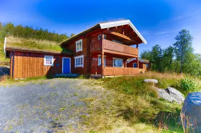 a log cabin with a grass roof on a hill at Large Cabin Retreat Perfect For Family Gatherings in Beitostøl