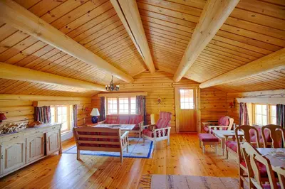 a room with a wooden ceiling with tables and chairs at Large Cabin Retreat Perfect For Family Gatherings in Beitostøl
