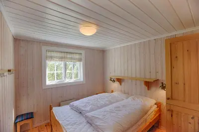 a bedroom with a bed in a room with a window at Large Cabin Retreat Perfect For Family Gatherings in Beitostøl