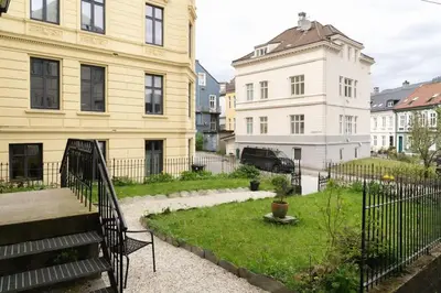 a view of a yard with a building and a house at DINBNB Apartments l Historical Building I 100m To University Museum in Bergen
