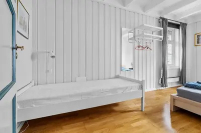 a bed in a room with white walls at Experience Norway's History I With Free Parking in Bergen