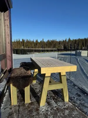 a wooden picnic table sitting next to a parking lot at Mosetertoppen Skistadion - Hafjell Ski Resort in Hafjell