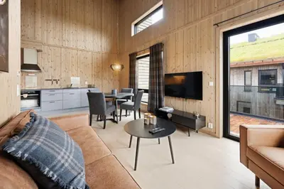 a living room with a couch and a table at Mosetertoppen Skistadion - Hafjell Ski Resort in Hafjell