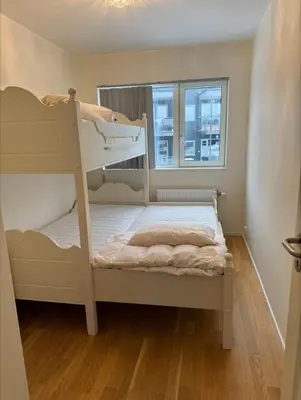a bedroom with two bunk beds and a window at Rekkehus til leie under ski-VM in Heimdal