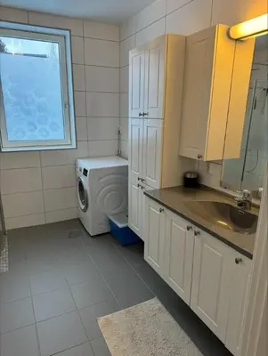 a kitchen with a washing machine and a window at Rekkehus til leie under ski-VM in Heimdal