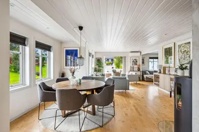 a kitchen and living room with a table and chairs at Sentral enebolig til utleie under Ski VM 2025 in Trondheim