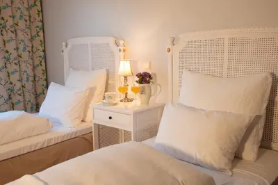 a bedroom with two beds and a table with a lamp at Tørvis Hotell in Luster