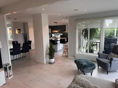 a living room and kitchen with a couch and chairs at Enebolig Trondheim syd in Trondheim