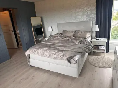 a bedroom with a large bed with a mirror at Enebolig Trondheim syd in Trondheim