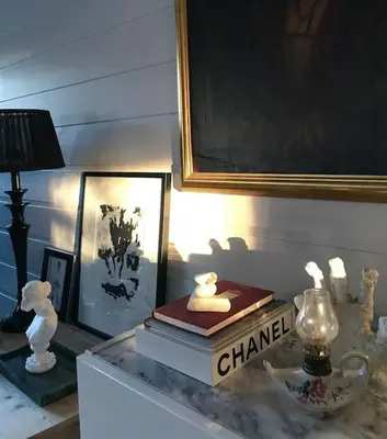 a table with two books and a lamp and a picture at Rekkehus til leie for ski-VM 2025! I nærheten av VM-arenaen! in Trondheim