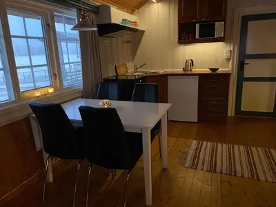 a kitchen with a white table and chairs at Tørresvangen in Tynset