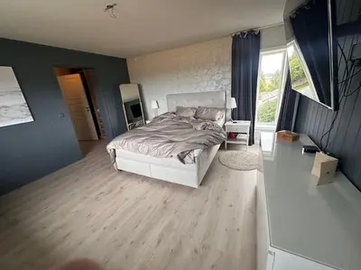 a bedroom with a white bed and a window at Stor enebolig Trondheim syd in Trondheim