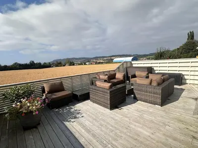 a patio with couches and chairs on a wooden deck at Stor enebolig Trondheim syd in Trondheim