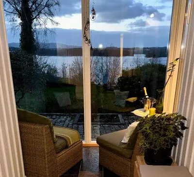 a screened in porch with a view of a lake at Panoramic Fjord View near Bergen in Bergen