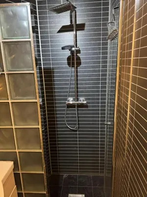 a shower in a bathroom with black tiles at Prime location, 400 m from the town centre in Vossevangen