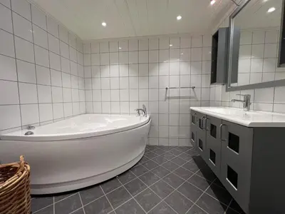 a white bathroom with a tub and two sinks at Large Balcony With Panoramic Mountain Views in Beitostøl