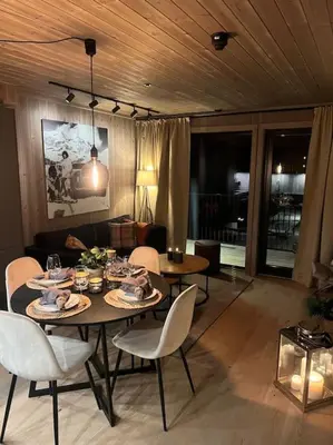 a dining table and chairs in a living room at Helt ny leilighet ski in- ski out i Hemsedal in Hemsedal