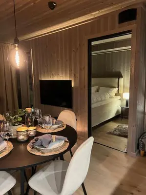 a dining room with a table and chairs and a bedroom at Helt ny leilighet ski in- ski out i Hemsedal in Hemsedal
