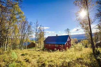 a red barn with a blue roof in a field at Charming Cabin Ski-In Access And Pet Friendly in Beitostøl