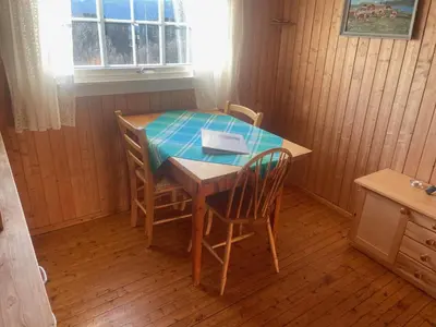 a table and two chairs and a table and a table and a window at Charming Cabin Ski-In Access And Pet Friendly in Beitostøl