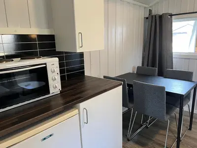 a kitchen with a microwave and a table with chairs at Granmo Camping in Oppdal