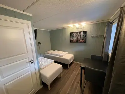 a small room with two beds and a table at Granmo Camping in Oppdal