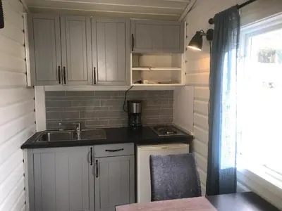 a small kitchen with white cabinets and a sink at Granmo Camping in Oppdal