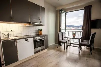a kitchen and dining room with a table and a window at Beautiful Harbour Apartment With French Balcony in Bergen