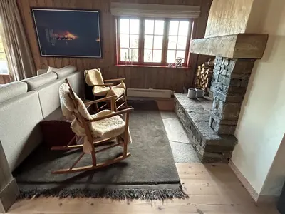 a living room with two chairs and a fireplace at Spacious cabin with beautiful Geilo views in Geilo