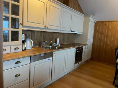 a kitchen with white cabinets and a sink at Bright 2-Bedroom With Terrace And Fireplace in Beitostøl