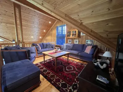 a living room with blue couches and a table at Grand Log Cabin With Fireplace And 12-14 Beds in Beitostøl