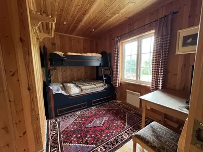 a small room with a bed in a cabin at Grand Log Cabin With Fireplace And 12-14 Beds in Beitostøl
