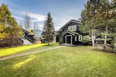 a large black house with a grass yard at Hemsedal Mountain Retreat in Hemsedal